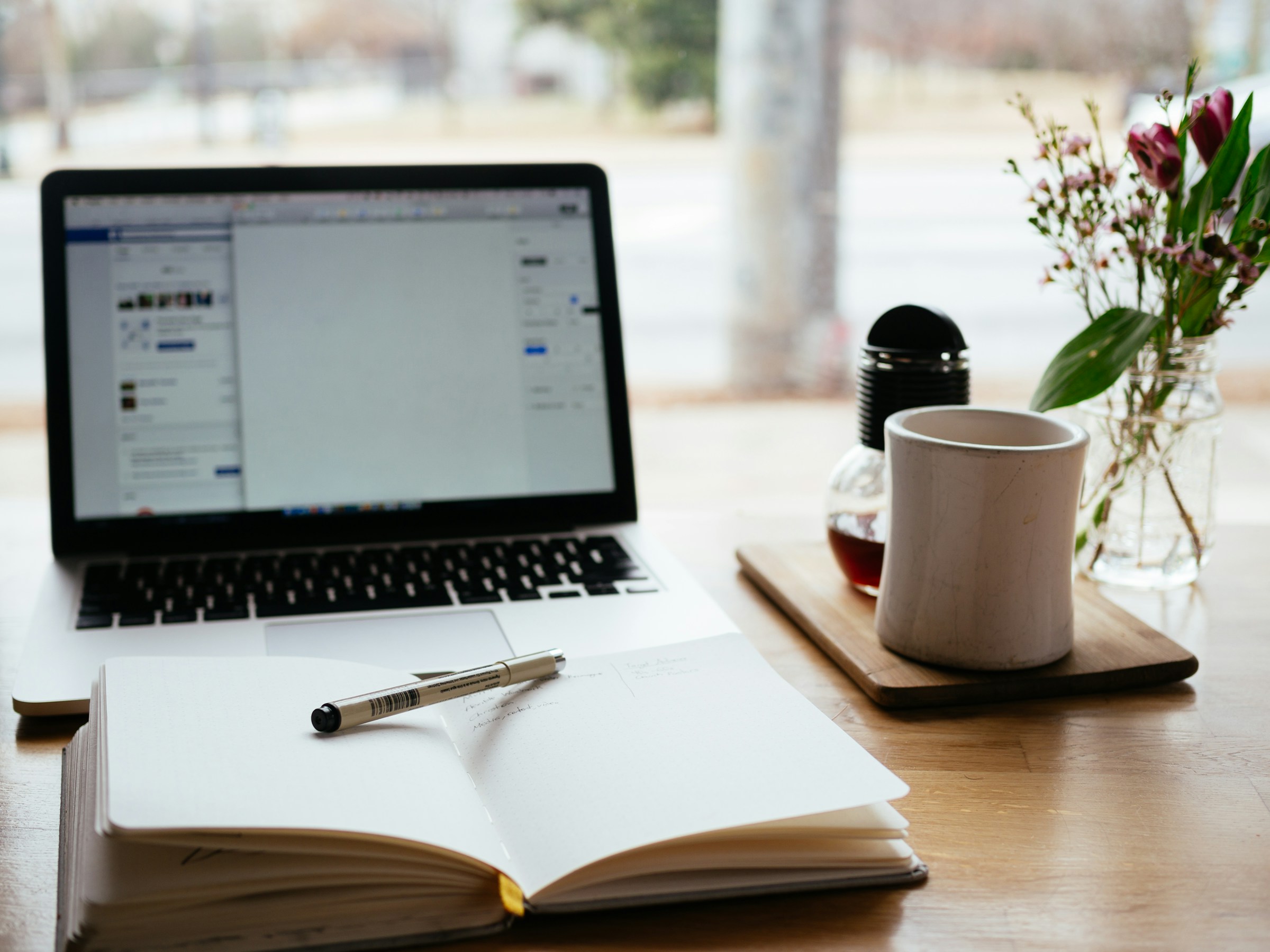 study desk with open book and laptop